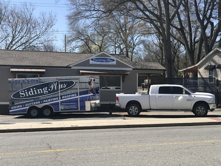 A white pickup truck towing a trailer with advertising for siding installations & repairs, painting, and roofing services, parked in front of a building with similar signage.